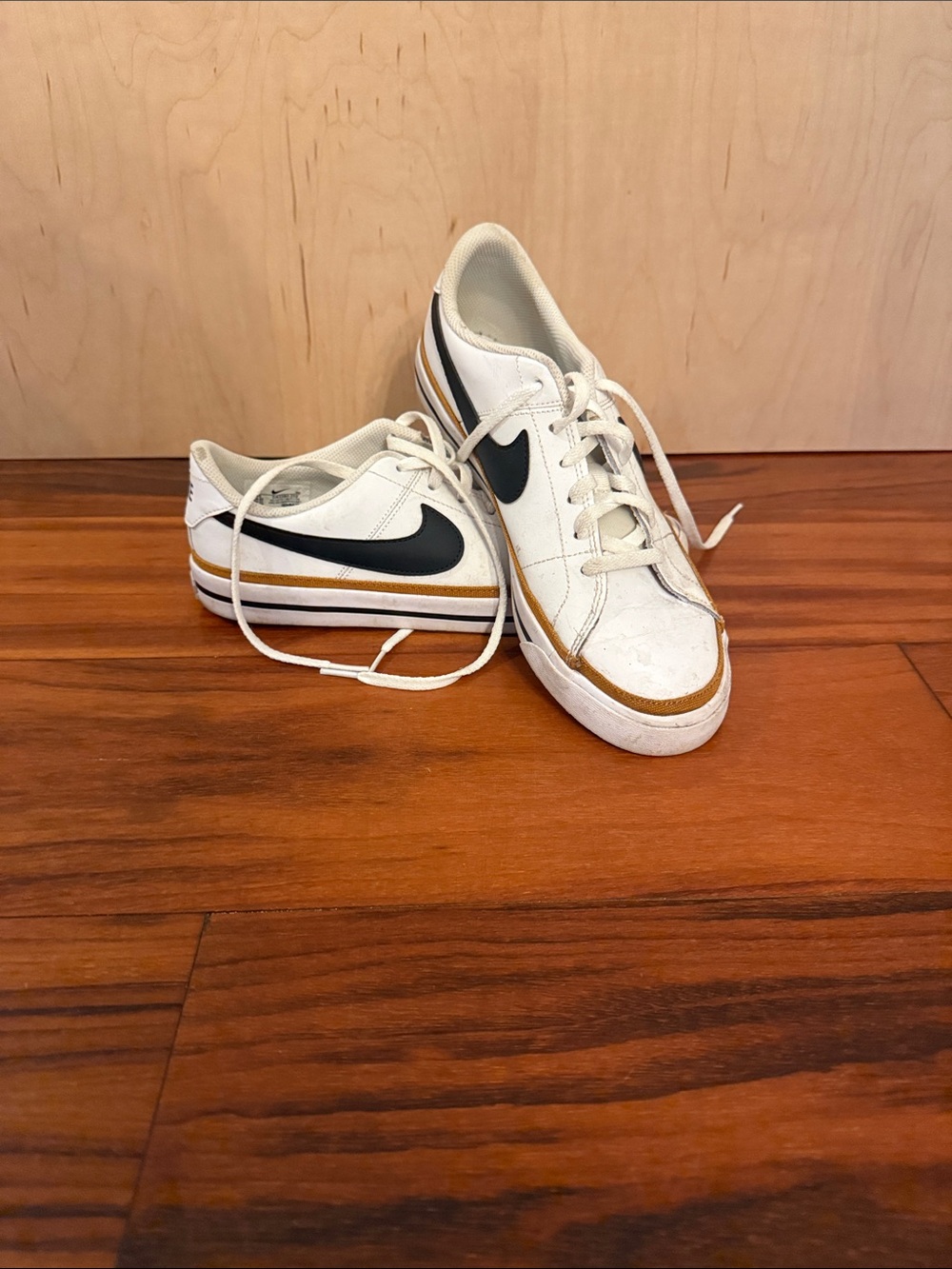 Nike Kids White Sneakers with Black Swoosh and Gold Accent